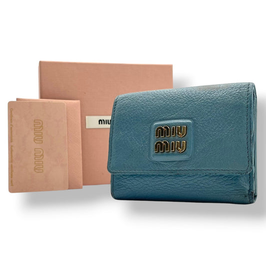 良品 ミュウミュウ miumiu 三つ折り財布 折り財布 コンパクトウォレット ミニ財布 マドラス レザー 本革 ライトブルー 水色 メタルロゴ ゴールド金具 レディース エレガント キュート フェミニン カジュアル デイリー 通勤 通学 上品 大人 W1