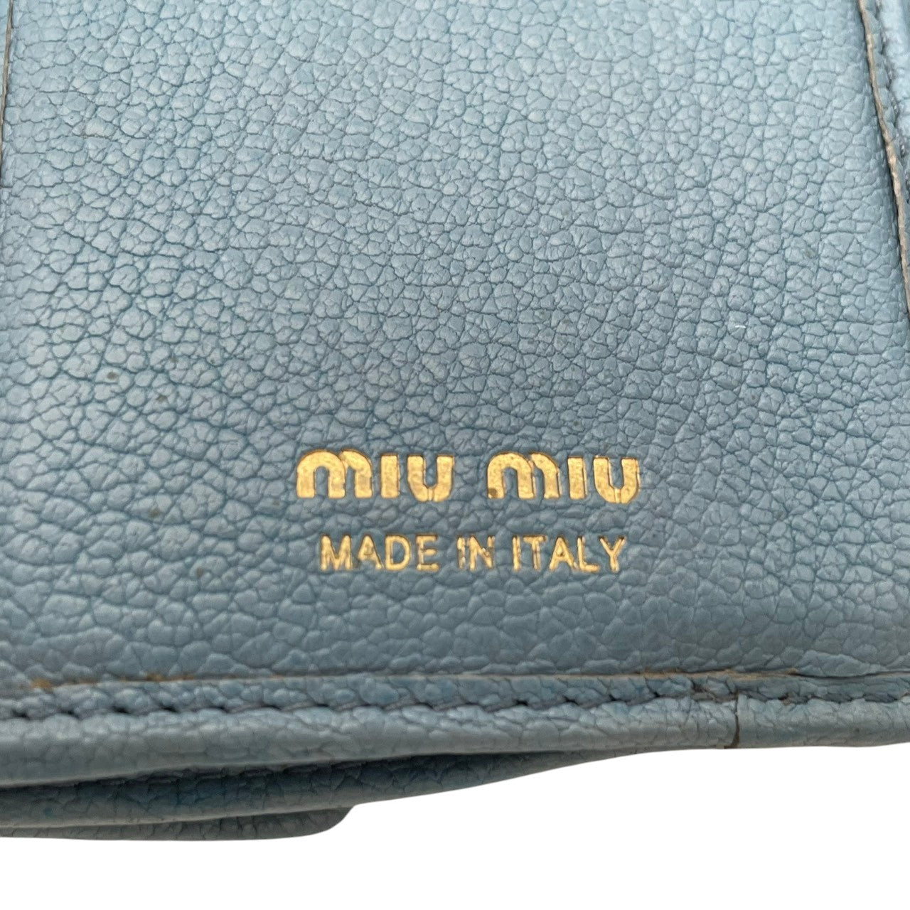 良品 ミュウミュウ miumiu 三つ折り財布 折り財布 コンパクトウォレット ミニ財布 マドラス レザー 本革 ライトブルー 水色 メタルロゴ ゴールド金具 レディース エレガント キュート フェミニン カジュアル デイリー 通勤 通学 上品 大人 W1