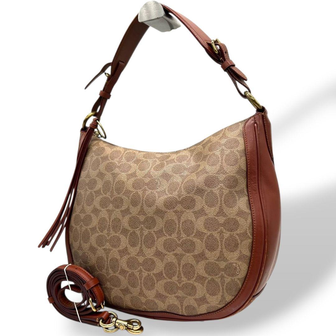 コーチ　ショルダーバッグ　茶　シグネチャー　ホーボー　2way　本革　s36　ハンドバッグ　トートバッグ　レザー　ワンショル　キャンバス　ブラウン　A4収納　斜め掛け可　チャーム付き　ゴールド金具　COACH　38580